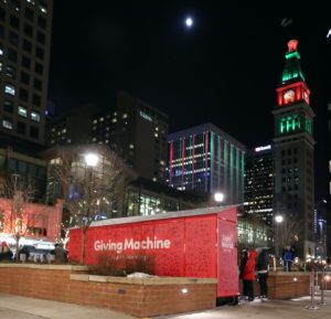 The Denver Giving Machines glow with the clock tower in the background.